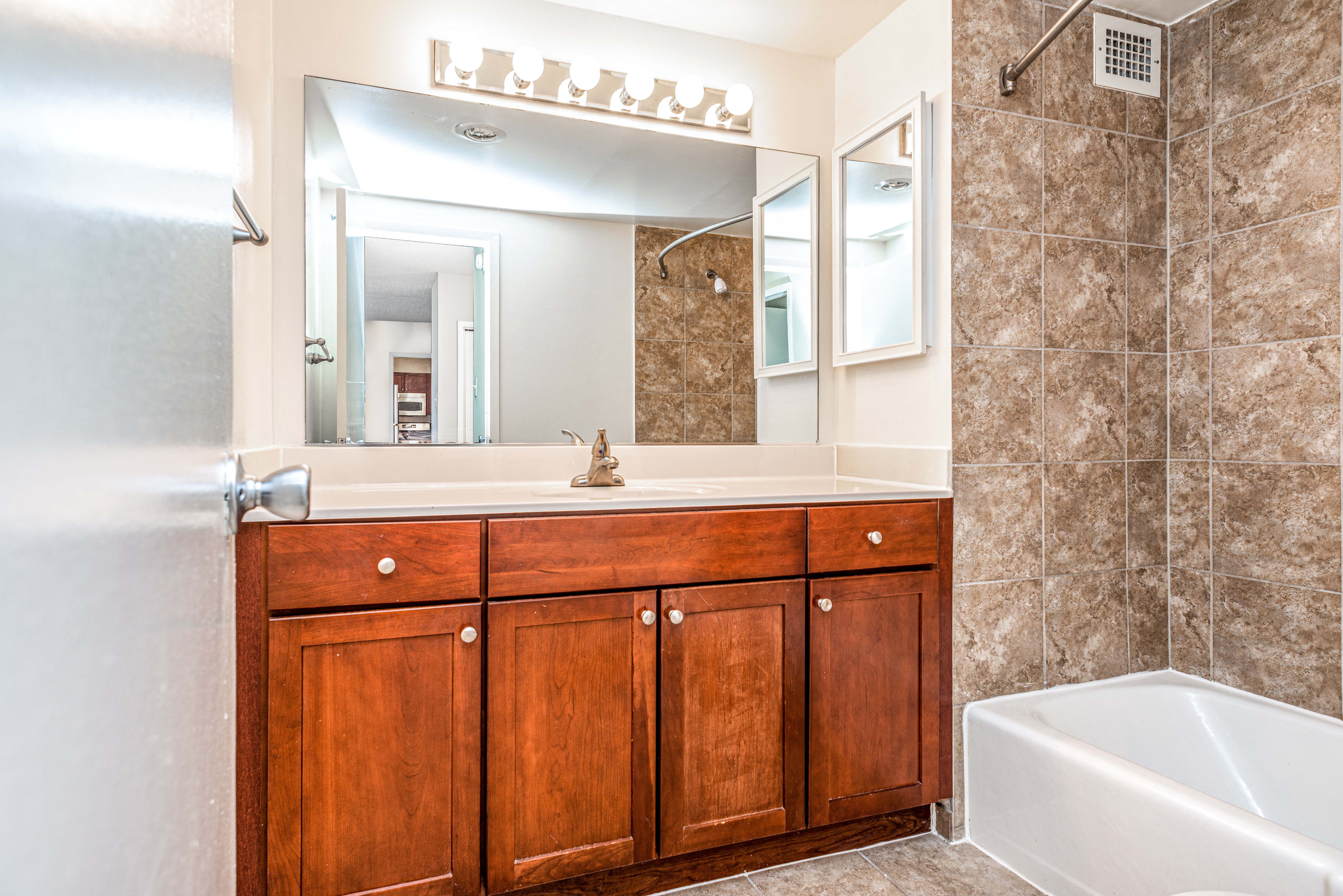 Updated bathrooms with tiled bathroom shower and tub, cherry maple vanity and premier lighting